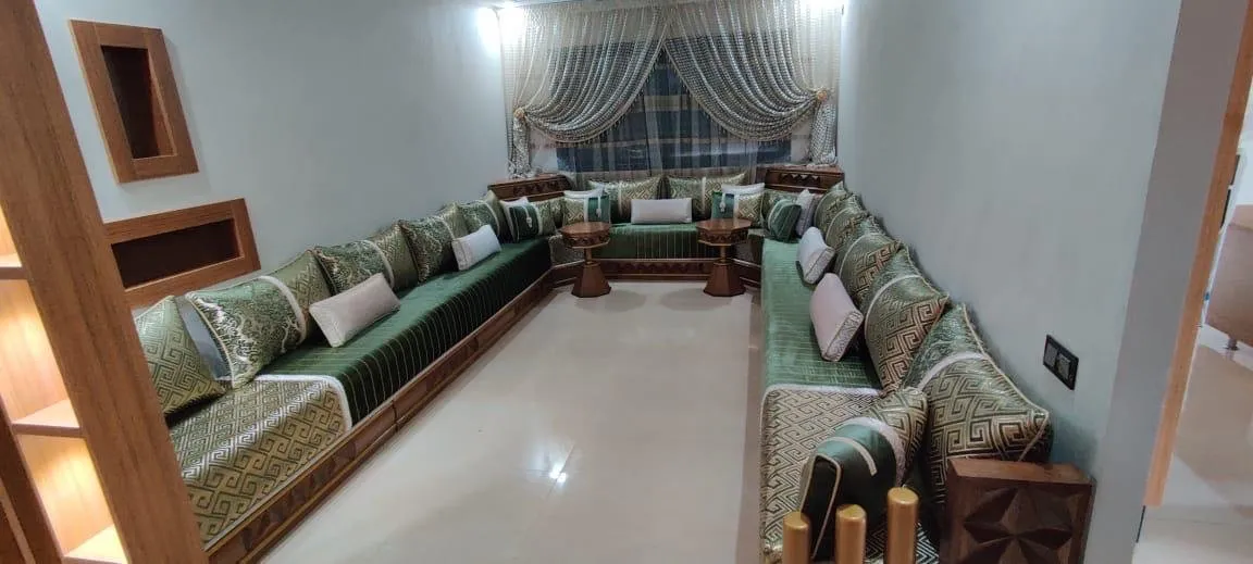 Long salon marocain vert en U à motif géométrique