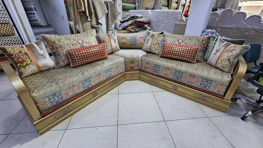 صالون مغربي ذهبي على شكل زاوية بوسائد مطرزة ووسادة حمراء